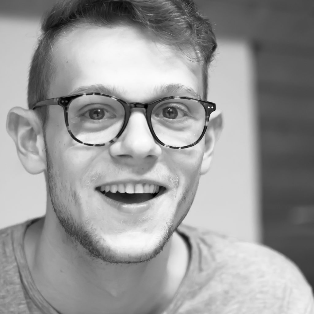 The black and white photo shows a portrait of Moritz Bussinger smiling into the camera.